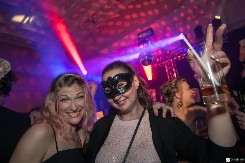 Nightclub Scene with Masked Reveler and Colorful Laser Lighting