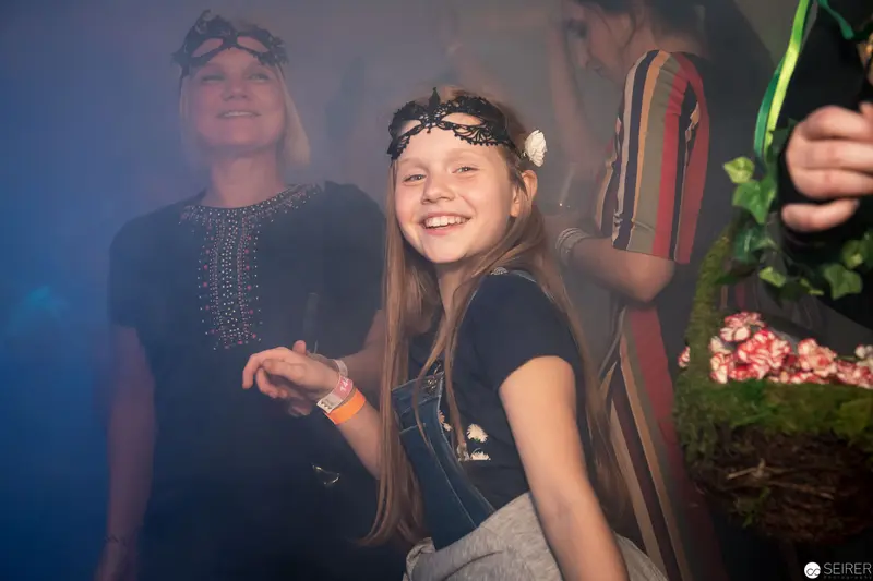 Young Festivalgoer Smiling Amid Misty Performance Atmosphere