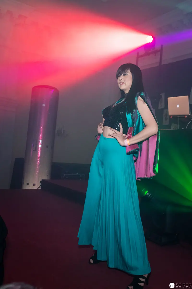 Woman in Turquoise Dress Illuminated by Dramatic Stage Lighting