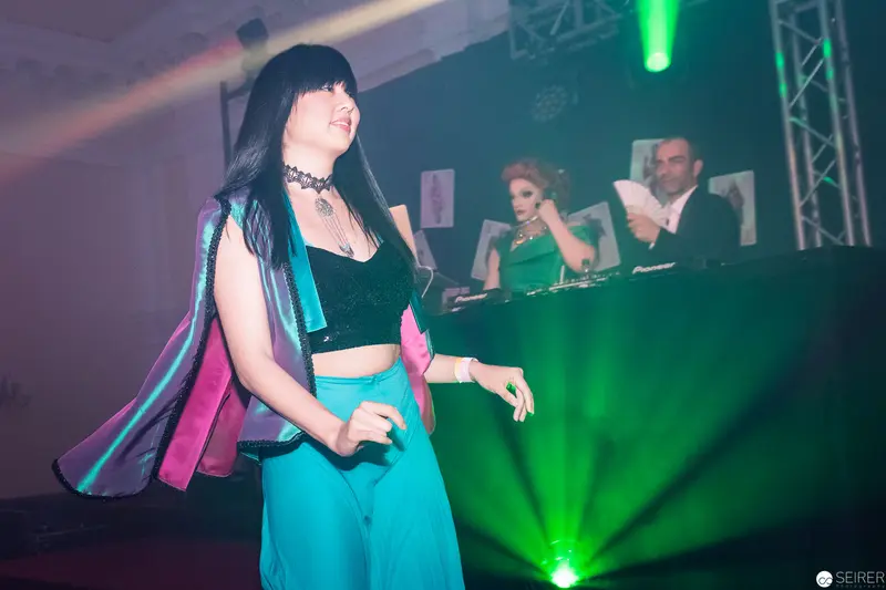 Electronic Music Performance with Dancer in Vibrant Stage Lighting
