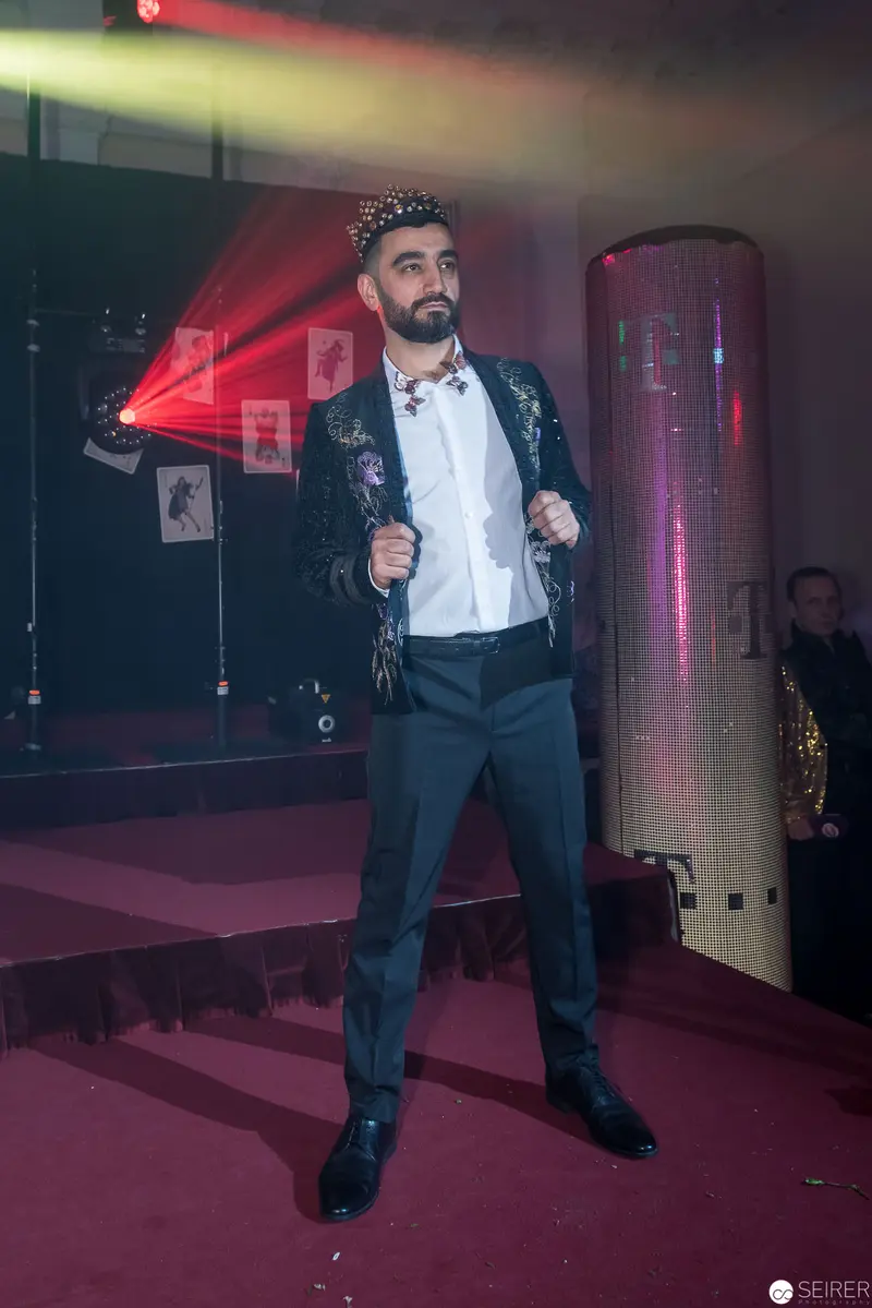 Formal Male Performance in Dramatic Stage Lighting with Red and Pink Hues