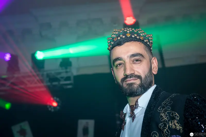 Ornate Performance Portrait with Laser Stage Lighting and Decorative Headwear