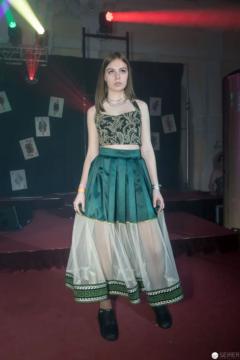 Young Woman in Emerald Green Crop Top and Layered Skirt at Staged Event