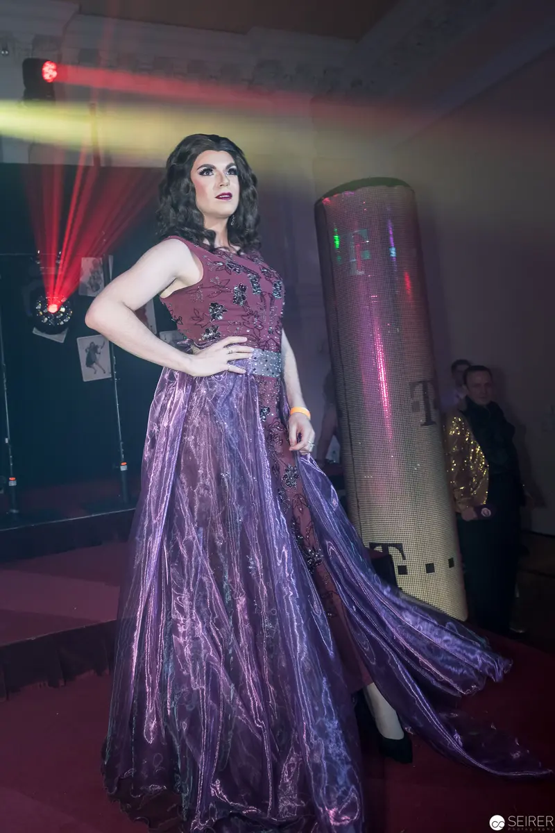 Performer in Violet Gown Striking Dramatic Pose on Event Stage