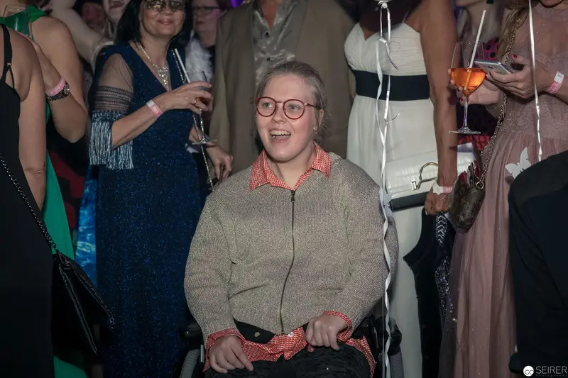 Festive Social Gathering with Jubilant Participant in Glasses and Cozy Sweater
