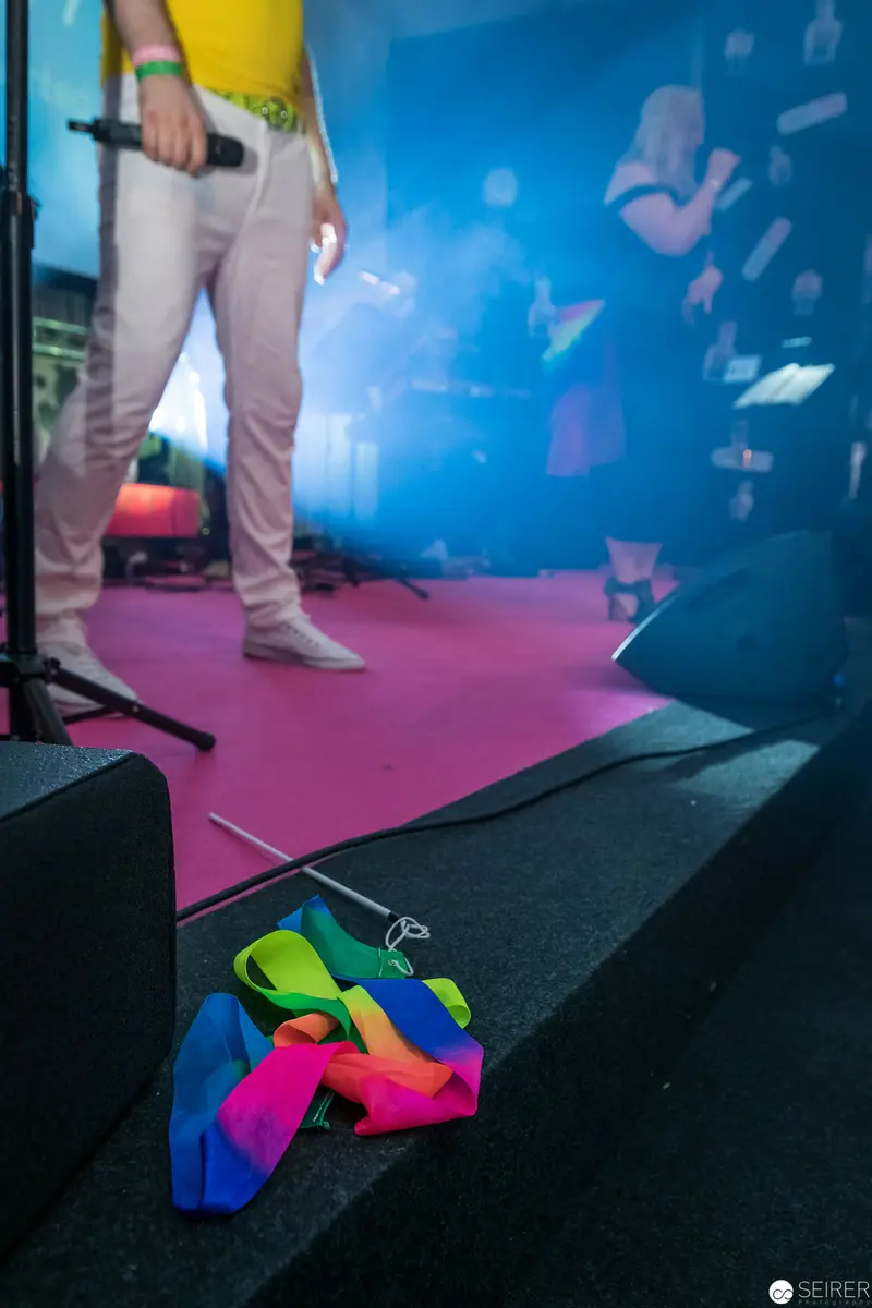 Multicolored Equipment on Stage Platform with Performer Legs in Background