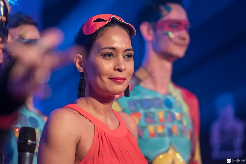 Performer in Coral Top with Pink Eye Mask During Vibrant Stage Performance
