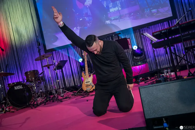 Passionate Performer Kneels in Dramatic Worship During Music Performance