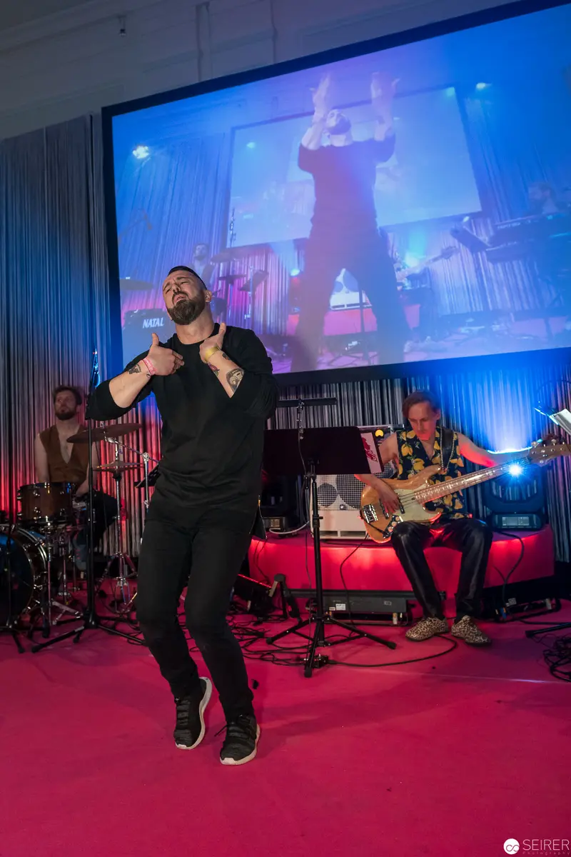 Live Music Performance with Vocalist and Band on Vibrant Pink Stage