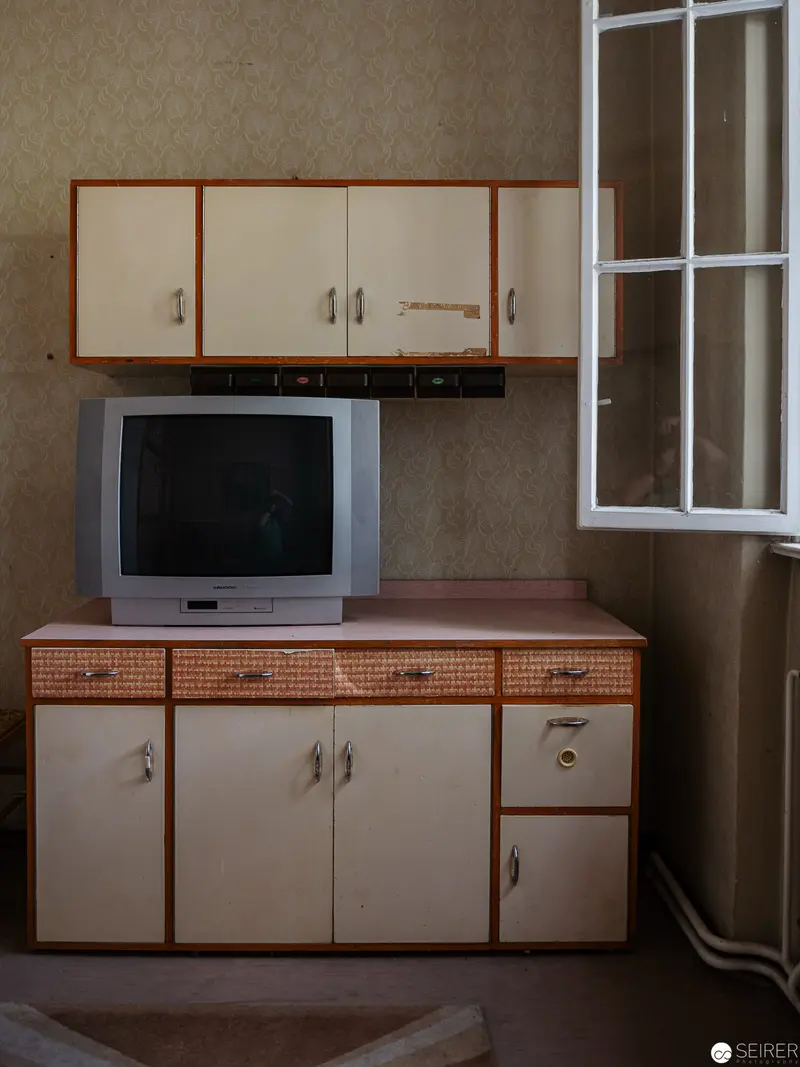 Vintage Interior with Retro Television and Minimalist Kitchen Cabinetry