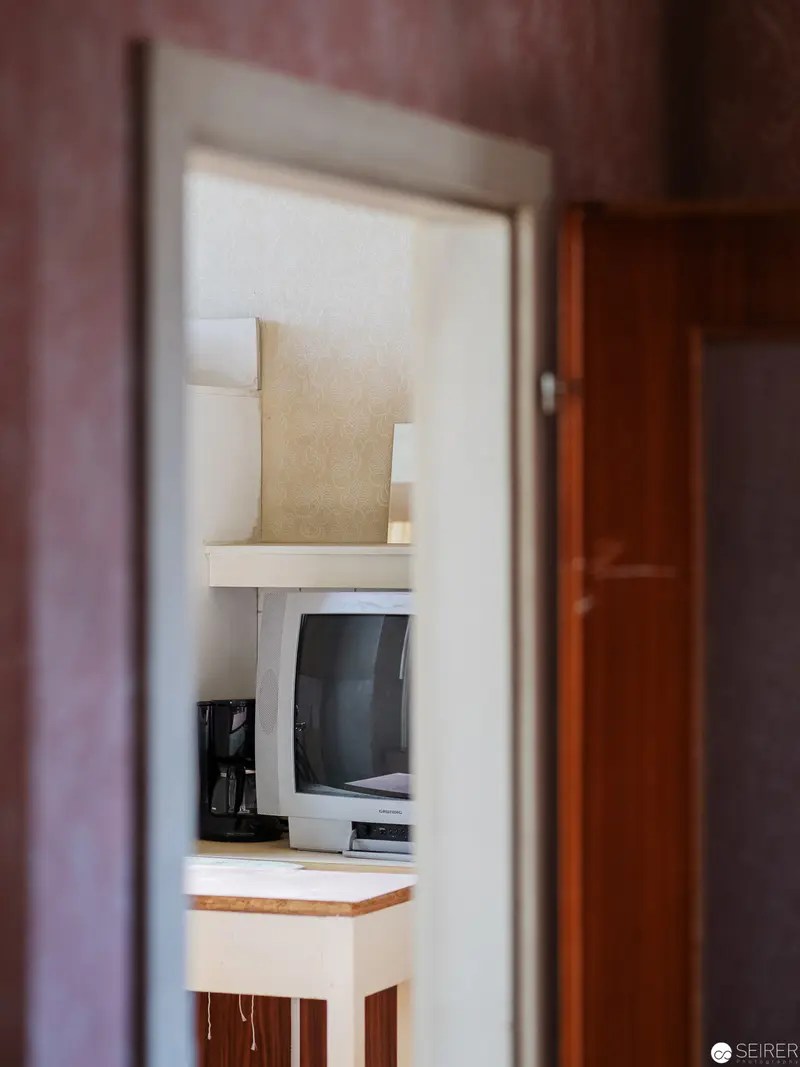 Intimate Workspace Interior: Computer Framed Through Doorway in Soft Light