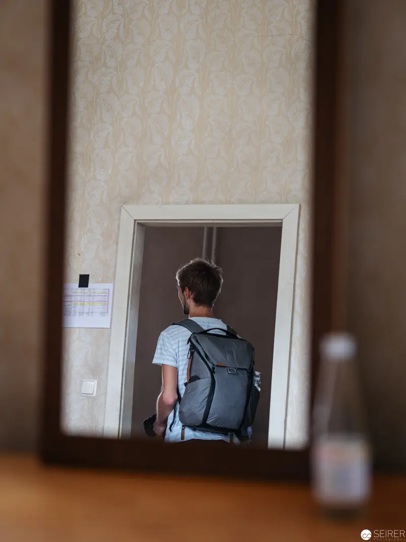 Backpack-Wearing Individual Reflected in Mirror at Film Location for "Nevrland"