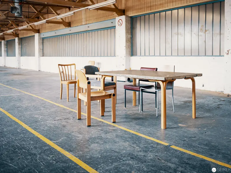 Minimalist Interior with Wooden Chairs in Industrial Warehouse Space