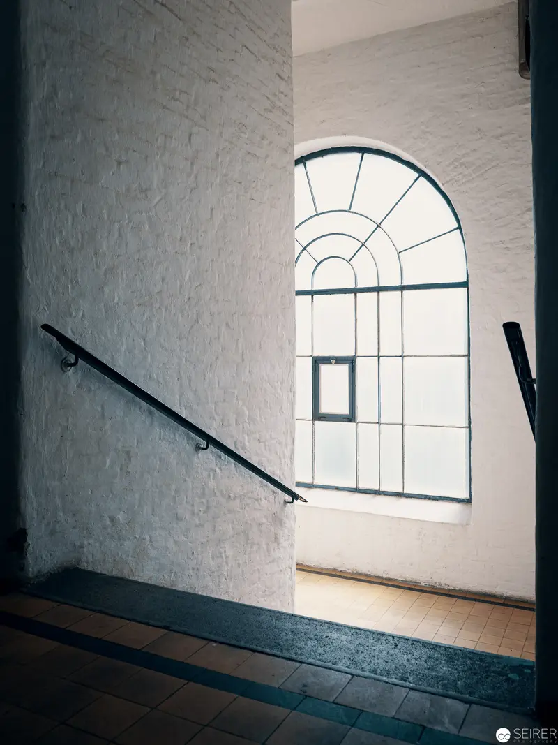 Architectural Geometry: Arched Window and Staircase in Minimalist Interior