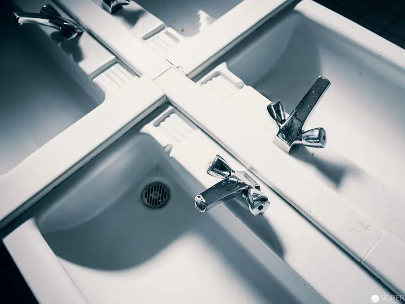 Modernist Sink Installation with Geometric Water Fixtures and Angular Shadows