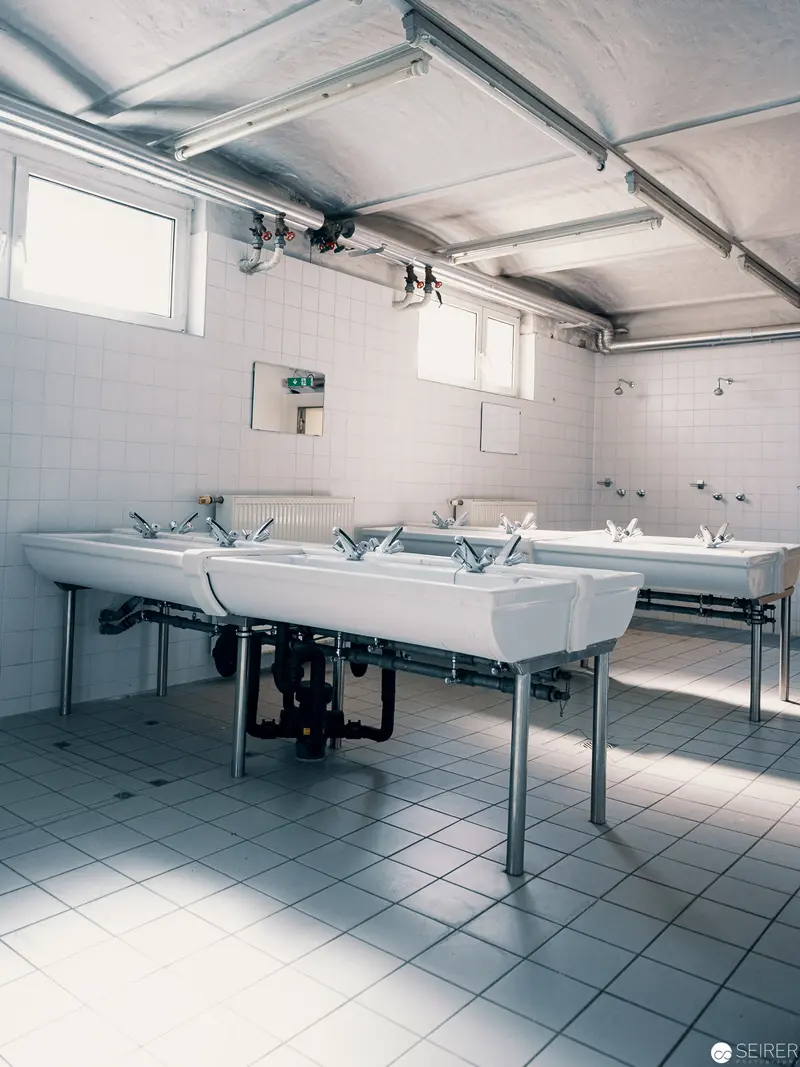 Minimalist Washroom Interior with Industrial Ceramic Sinks and Tiled Surfaces