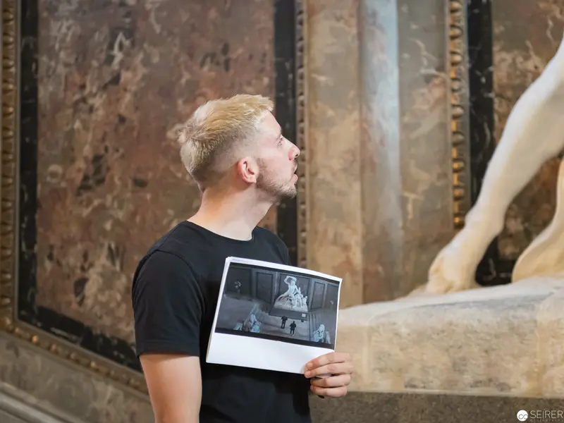 Museum Visitor Comparing Photographic Memory with Gallery Sculpture