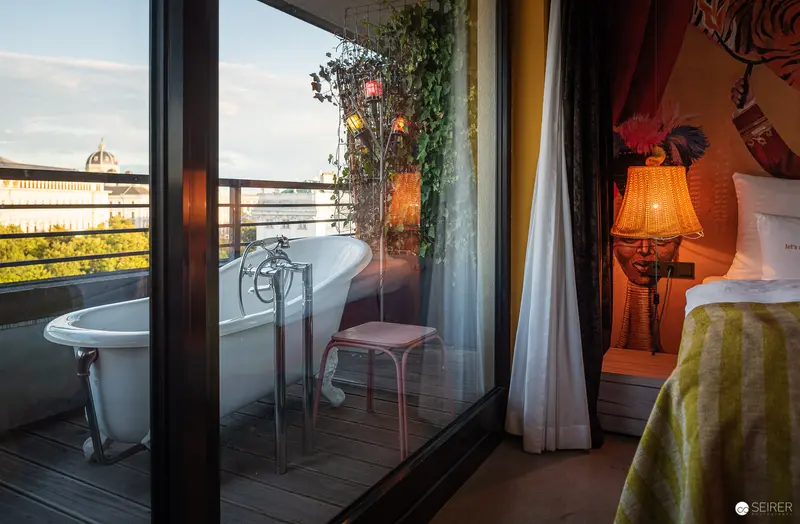Intimate Urban Retreat: Bathtub on Balcony with Ambient Evening Lighting