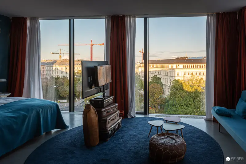 Urban Hotel Room with Panoramic City View and Construction Crane