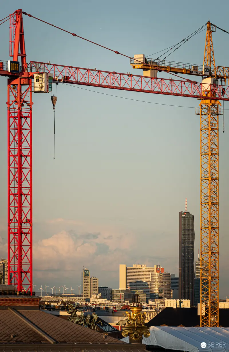 Urban Construction Site with Tower Cranes Framing Metropolitan Skyline