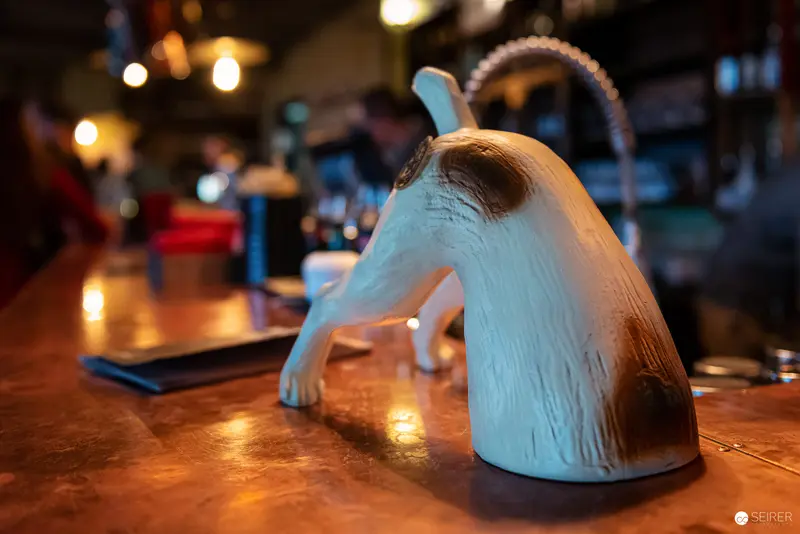 Ceramic Teapot Sculpture Illuminated on Warm Wooden Bar Surface