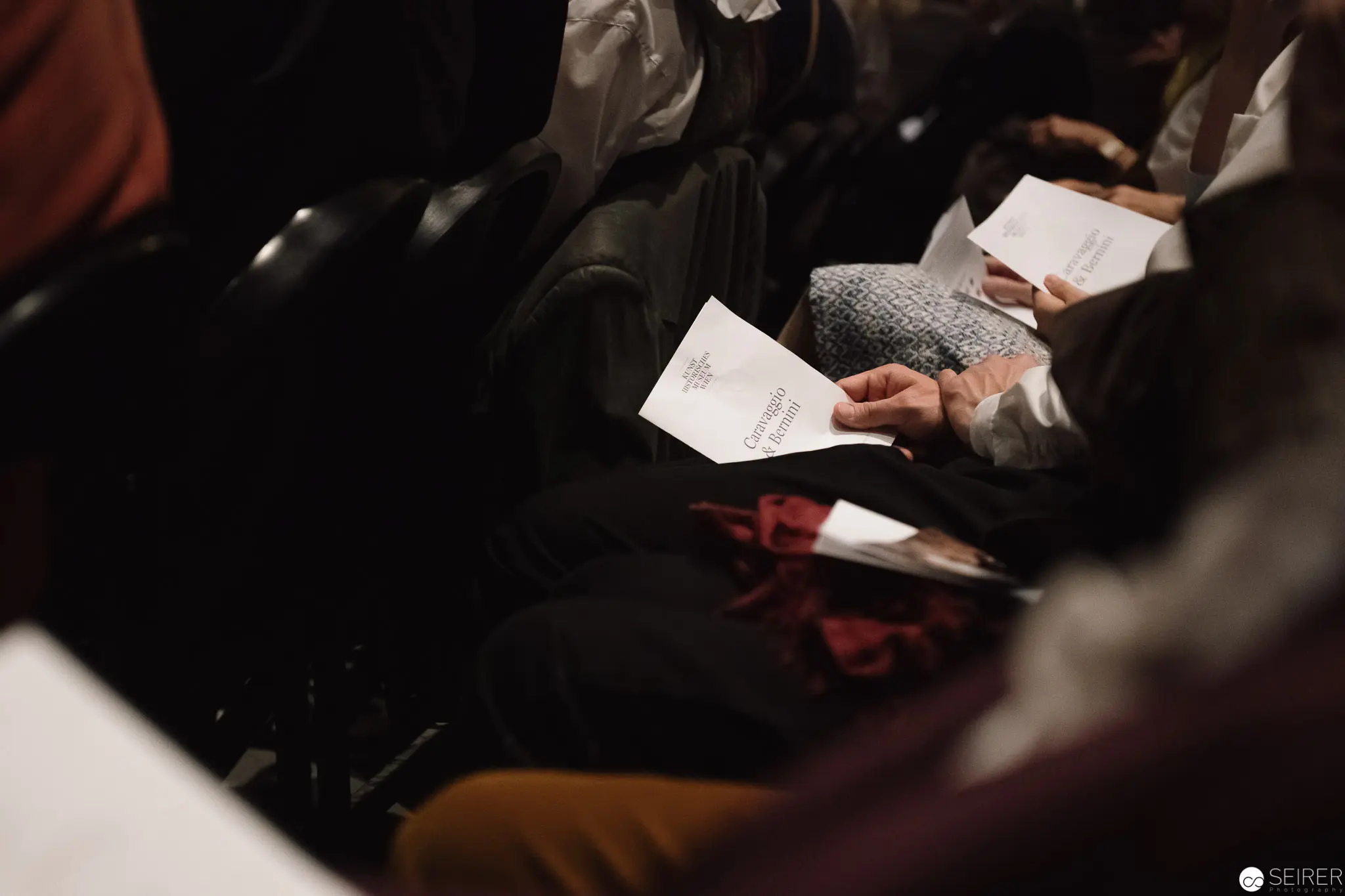 Attendees Studying Documents at Caravaggio & Bernini Exhibition Opening
