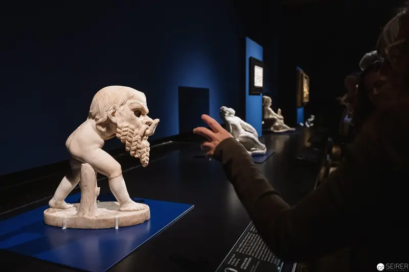Baroque Sculpture of Bearded Figure on Blue Display at Museum Exhibition