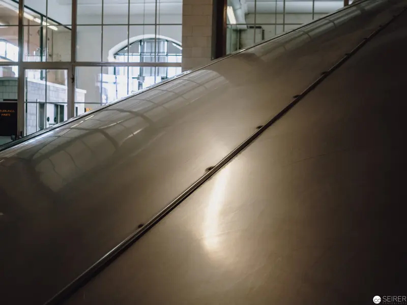 Metallic Surface Reflecting Architectural Interior with Dramatic Light Gradient