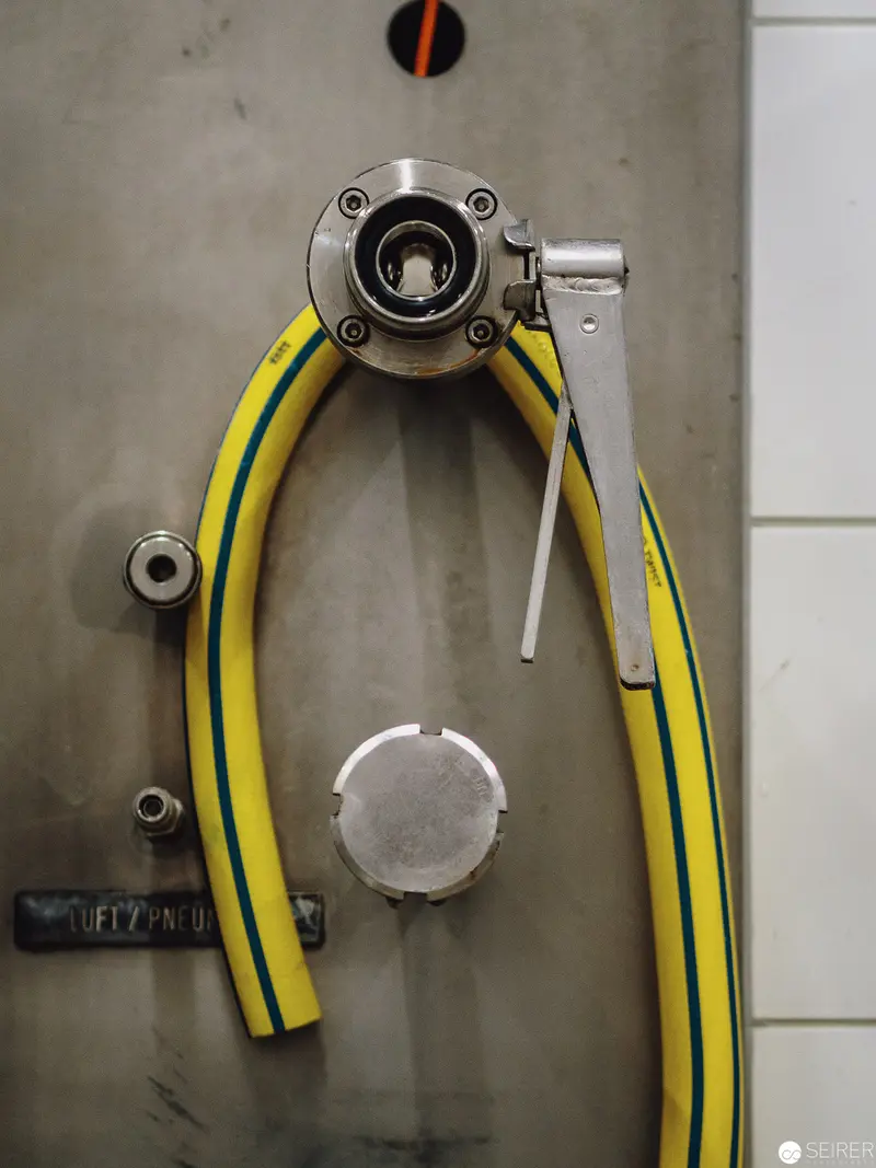Industrial Safety Valve with Yellow Reinforced Hose on Metallic Surface