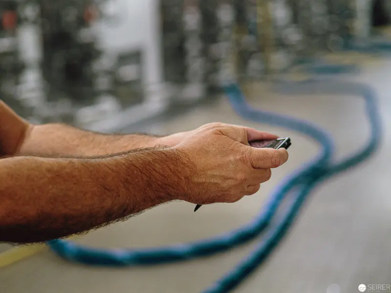 Technician's Hand Manipulating Electrical Cable in Industrial Setting