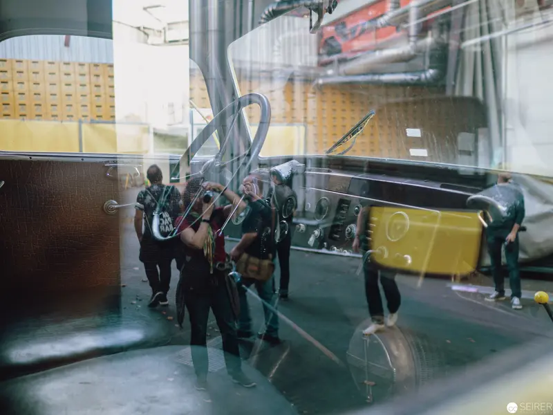 Blurred Figures in Transit Through Reflective Industrial Interior Space