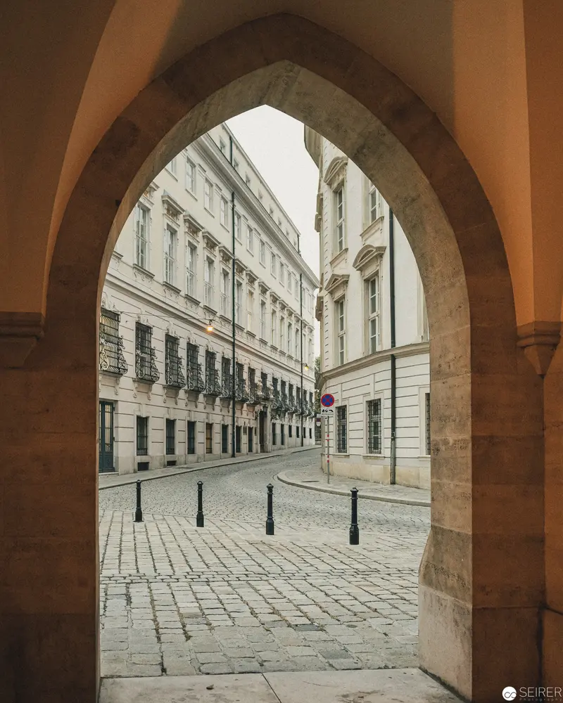 Gothic Archway Framing Historic European Street in Soft Architectural Perspective