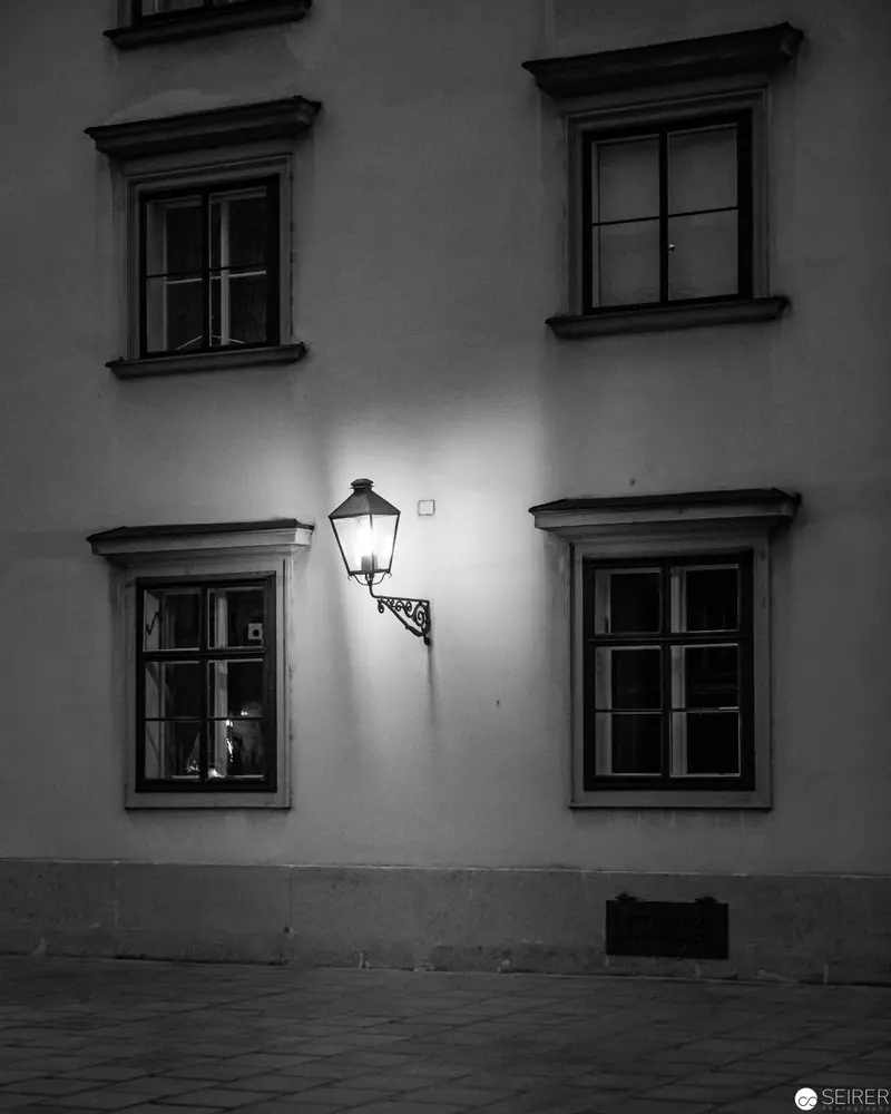 Nocturnal Urban Geometry: Street Lamp Illuminating Façade Windows at Twilight