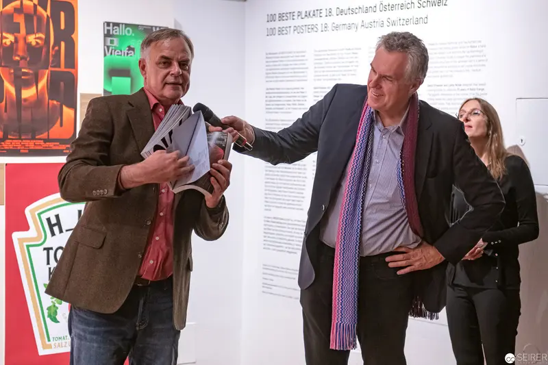 MAK Museum Colleagues Engaged in Animated Interaction During Exhibition