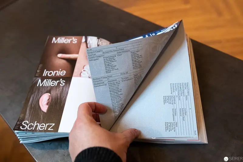 Hands Turning Pages of Ironie Miller's Scherz Book at Cultural Publication Event