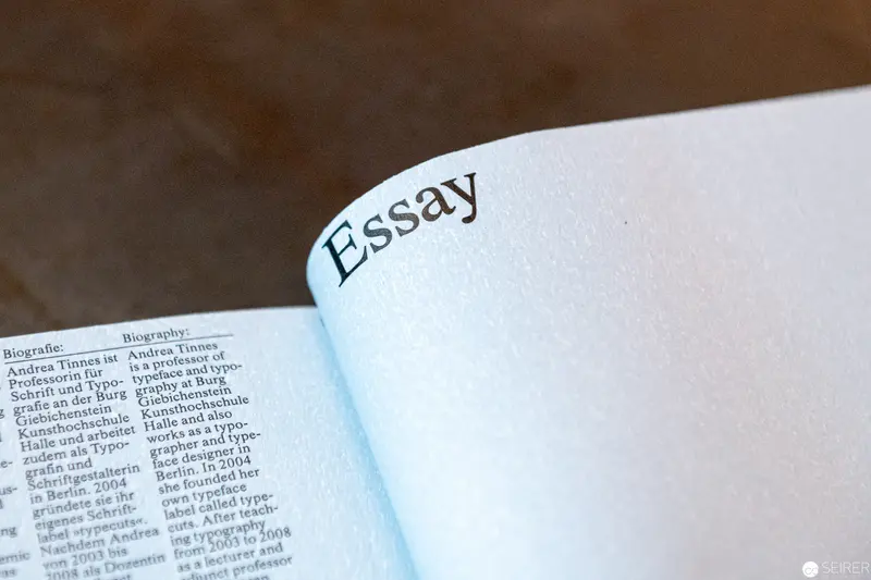 Open Book Revealing "Essay" Section with Biographical Text Margin