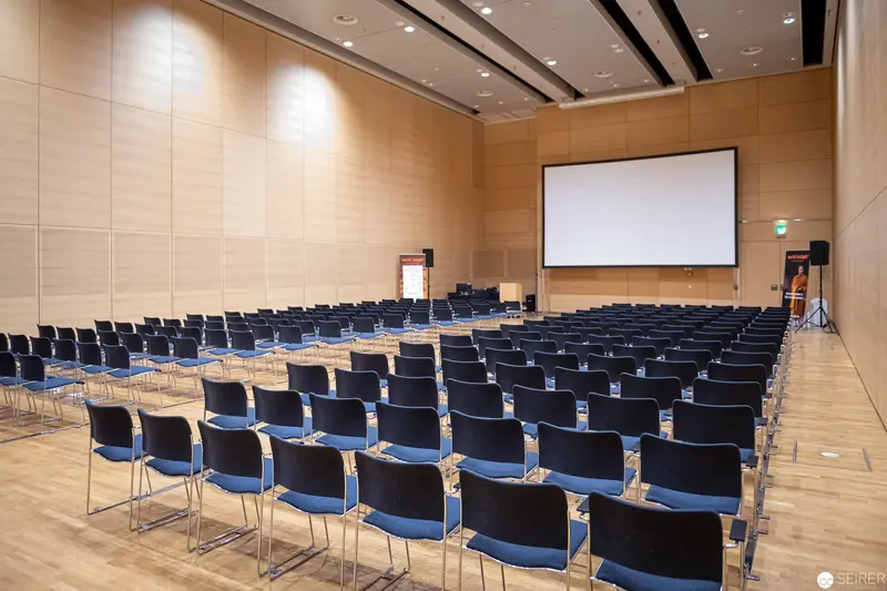 Empty Conference Room with Projection Screen and Blue-Black Chairs