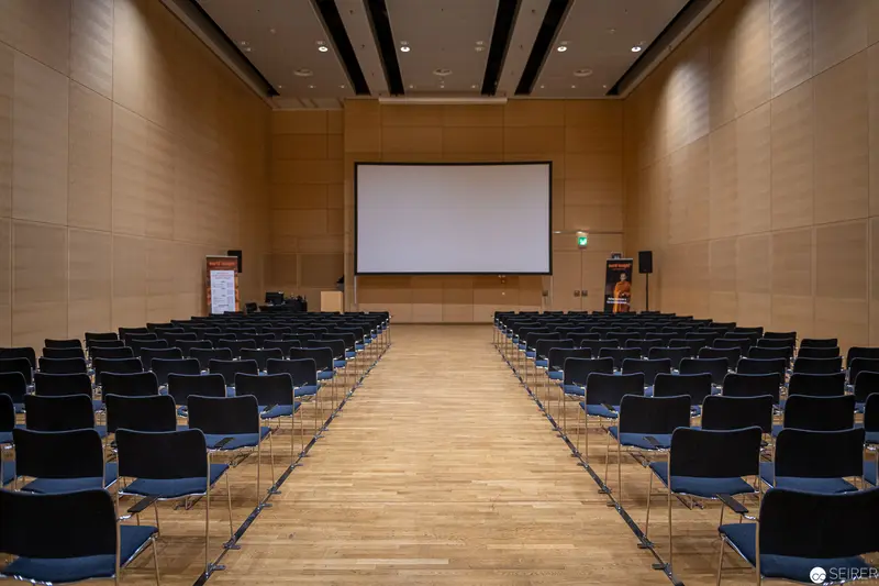 Empty Lecture Hall with Projection Screen and Arranged Seating