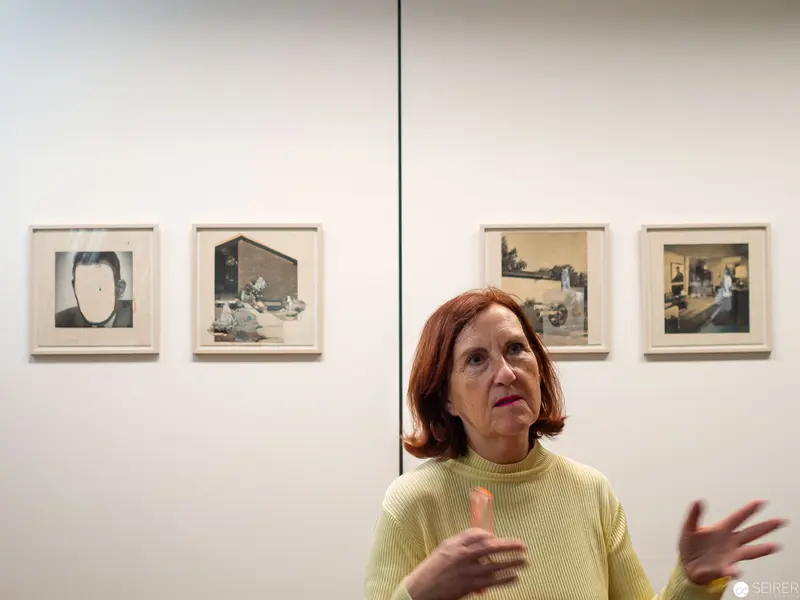Gallery Curator Discusses Framed Artwork During Exhibition Installation