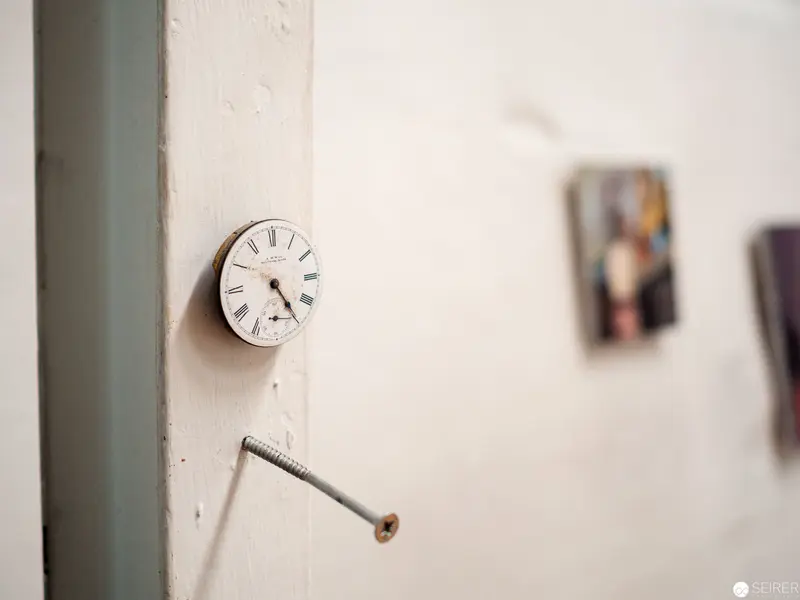 Suspended Timepiece with Exposed Screw on Minimalist Wall