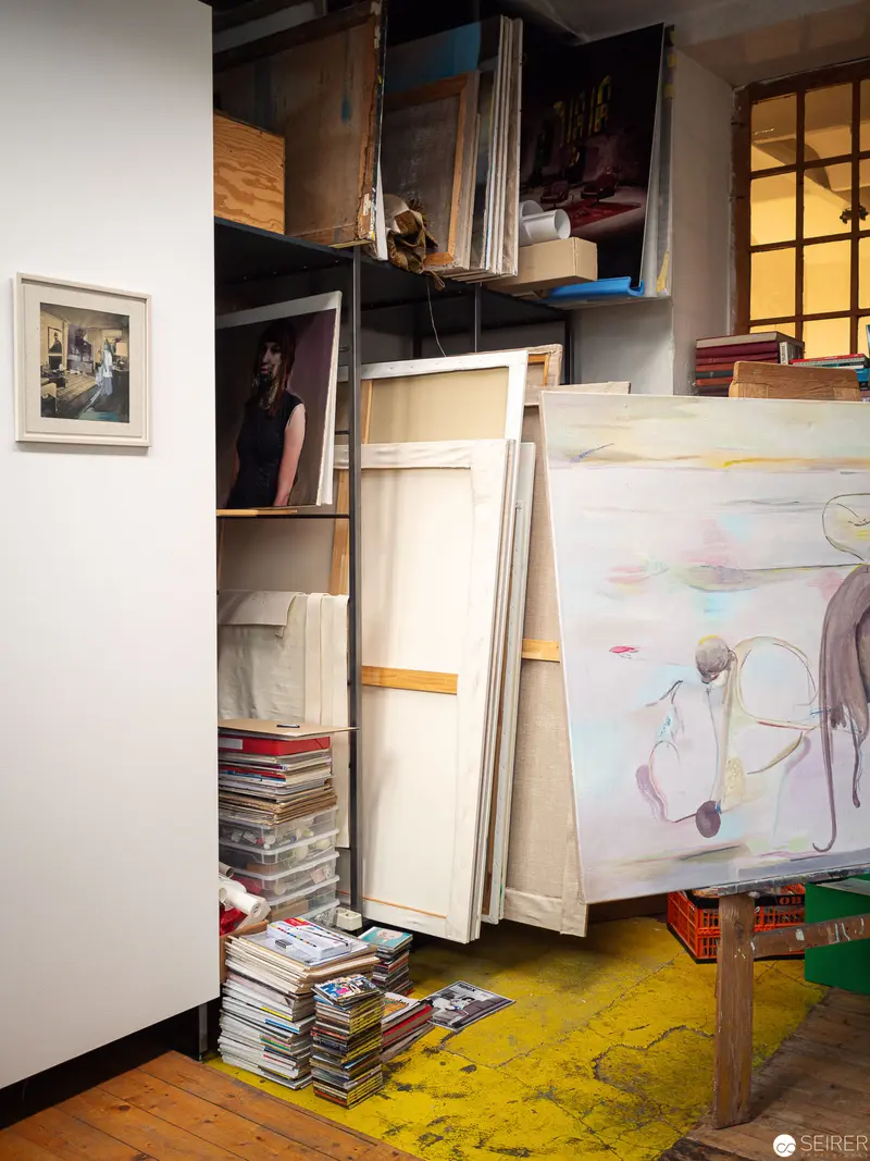 Artist's Studio Corner with Unfinished Canvases and Scattered Reference Materials