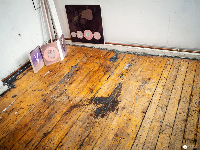 Weathered Wooden Floorboards with Abstract Art in Corner Composition