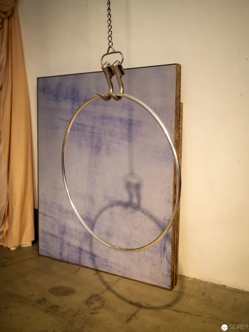 Suspended Circular Frame Intersecting Monochromatic Canvas in Studio Setting