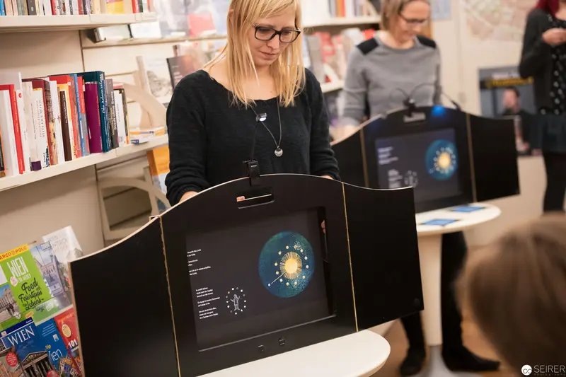 Woman Presenting Interactive Digital Display in Library Setting