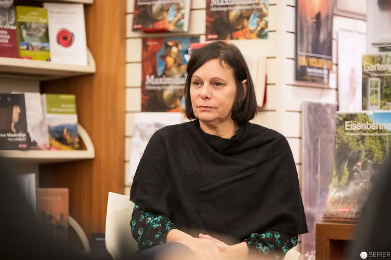 Woman in Black at Gallery Event with Framed Photographs