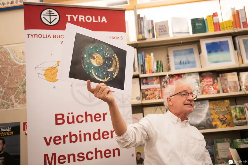 Man Holding Illustrated Book at Tyrolia Bookstore Display