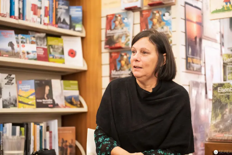 Woman Speaking at Literary Event in Bookstore Setting
