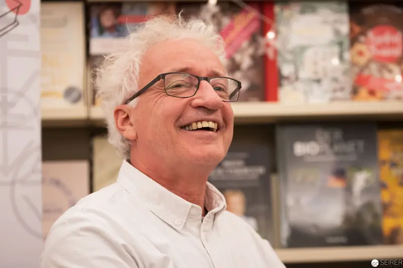 Man in White Shirt Smiling at Gallery or Museum Event