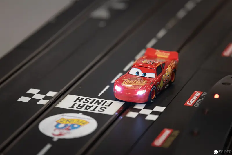 Lightning McQueen Slot Car Racer Illuminated on Checkered Finish Line Track
