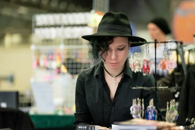 Artist in Black Hat Studies Craft at Vienna ComicCon 2019 Vendor Display